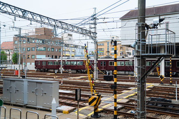 industrial railway landscape with many live wires overhead. cityscape of railroad connection with a train about to leave.