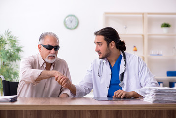 Old blind man visiting young male doctor