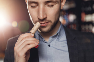 Professional sommelier waiter examining smell of wine cork