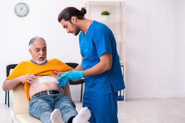 Old man visiting young male doctor