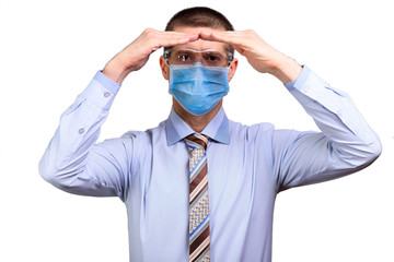 Businessman in shirt, medical mask and glasses looks into camera far away, holds hands house