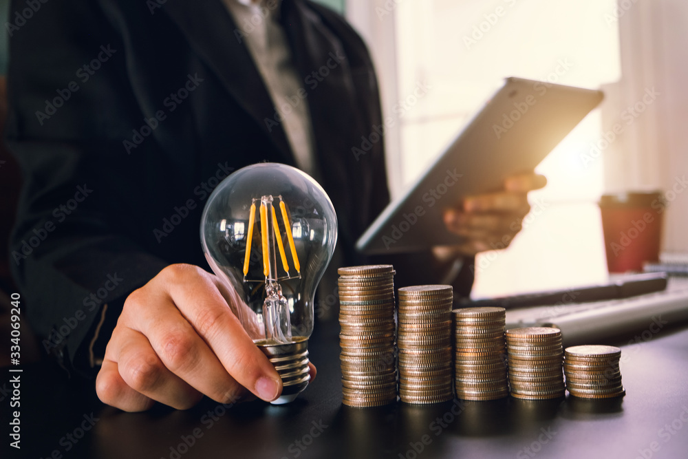 Poster business man hand holding lightbulb with using smartphone and calculator to calculate and money stac
