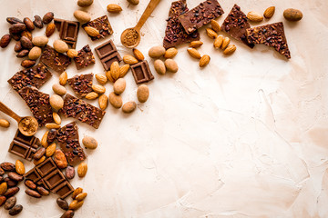 Chocolate frame. Broken slices and nuts on light background top-down copy space