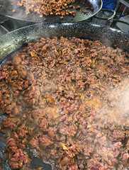 Beef cooking in frying pan at Borough Market, London UK