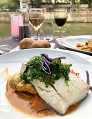 Haddock loin with shellfish juice, roast artichokes and carrots as the main course for dinner in Paris