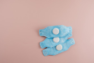 Protective respirators on a pale pink background. Virus protection concept. Prevention of the spread of the virus and the pandemic COVID-19. Personal protective equipment. Copy space.