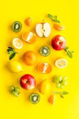 Colorful summer fruits background on yellow table top view