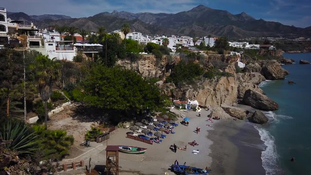 Nerja view with sea, beach and background mountains.