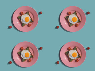 Breakfast, toasted bread with fried eggs, basil and cherry tomatoes on a pink plate, seamless pattern.