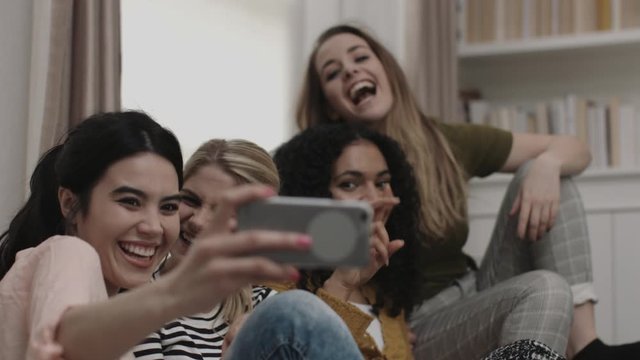 Group of female friends taking selfie on sofa