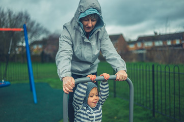 Little preschooler playing with his grandmother in the park