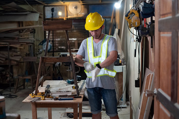 Handsome man wearing yellow helmet and glove,prepare for doing wood work at factory,Handmade design