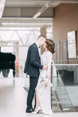 The bride and groom's romantic photo shoot. The newlyweds are happy together. Stylish modern couple in the Museum.