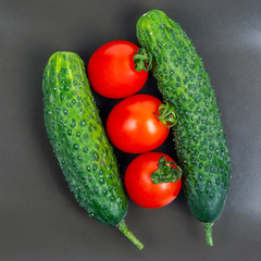 Fresh cucumbers and tomatoes on a gray background. vitamins and light breakfast