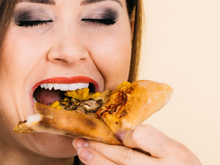 Woman eating hot pizza slice