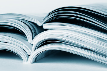 Pages of an open magazine, close-up, toning in blue. Selective focus.