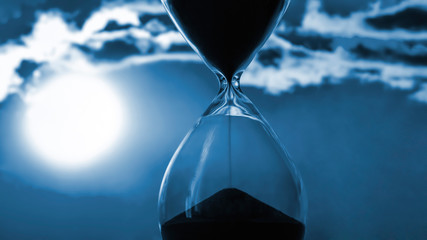Hourglass on the background of a sunset. The value of time in life. An eternity.