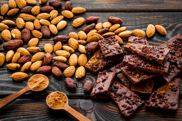 Homemade chocolate. Pieces, nuts on wooden table