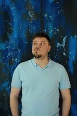  man in blue polo on a blue background