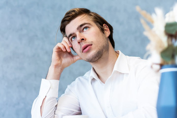 Handsome male looking away sitting at table in cafeteria