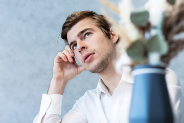 Handsome male looking away sitting at table in cafeteria