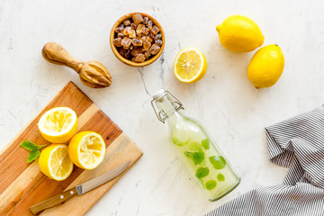 Make lemonade. Drink in bottle near utensil on white background top-down