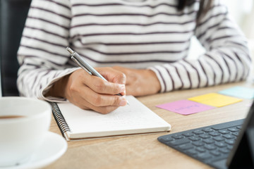  Hand Asian women write notebook with a pencil at the table in the  home office, Businesswoman work from home