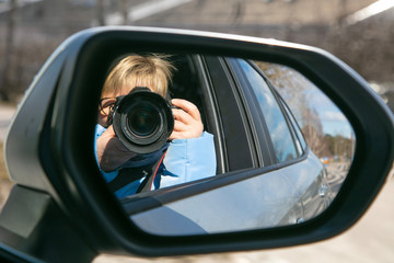 Woman takes pictures from a car window