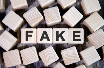 Fake - text on wooden cubes. And many cubes around