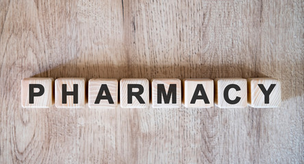 PHARMACY text word on wooden cubes on wooden background