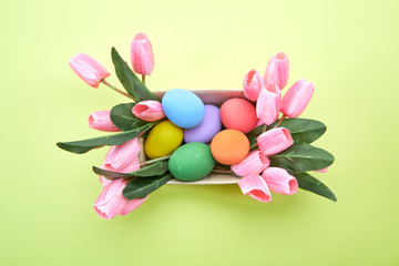 Fototapeta na wymiar Pink tulips in box and Egg Easter on yellow