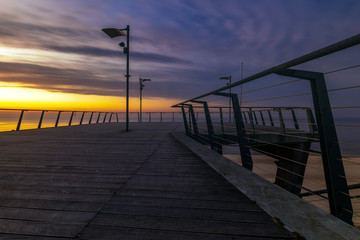 Naklejka na ściany i meble Wooden pier on the sea at dusk