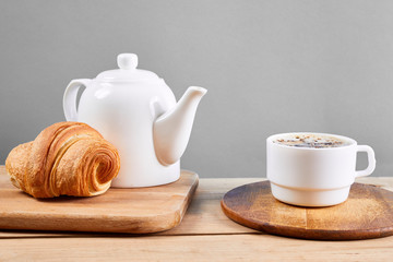 breakfast with croissants.Fresh crispy croissants and coffee on a wooden table