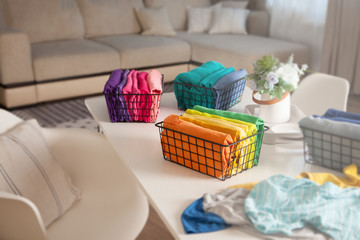 Spring cleaning of closet. Vertical tidying up storage. Neatly folded bright color clothes in the metal black baskets for wardrobe.
