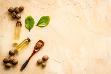 Nutmeg oil - perfume ingredient - on beige background top-down copy space