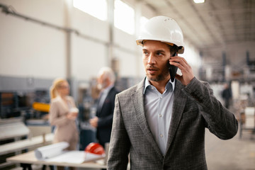 Businessman talking on cell phone. Young handsome man at work.