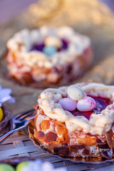 Easter Sponge cake nest. Nuts and oval sweet sweets in the form of eggs. Beautiful blurred background. Decoration for the holiday 