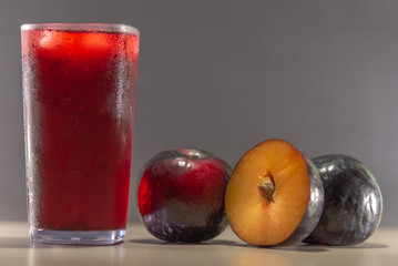 Plum juice and fruits (Prunus Alleghaniensis) on dark background