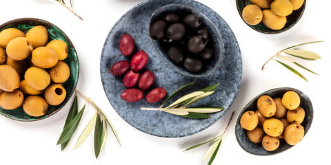 Olives overhead panorama on a white background. Green, black and red olives, shot from above