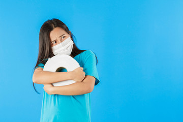 Asian woman hoarder tissue peper and wearing mask for virus on blue background, prevent the spread...