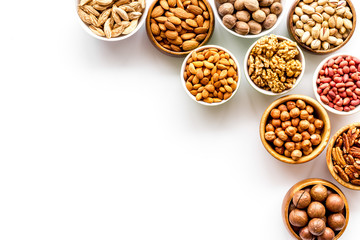 Set of macadamia, hazelnut, walnut, almond, pistachio, pecans nuts on white background top-down frame copy space