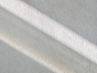 Sunrise drop shadow on old white concrete wall. 