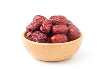 Dried red dates in a wooden bowl isolated on white background