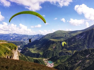 landscape with mountains and blue sky. Tandem paragliding