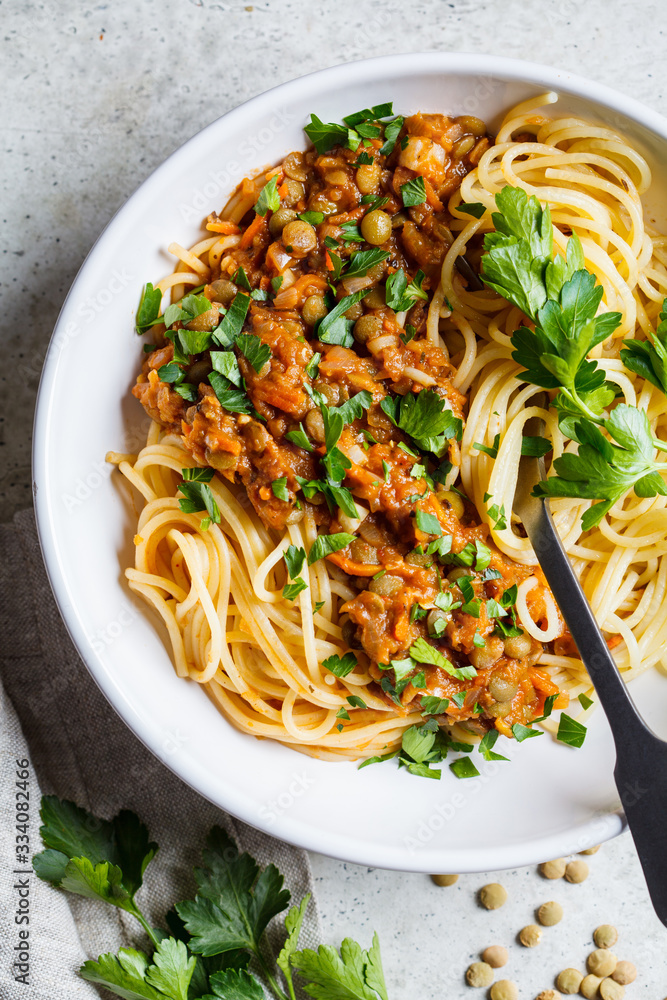 Poster vegetarian lentils bolognese pasta with parsley in white dish, top view. healthy vegan food concept.