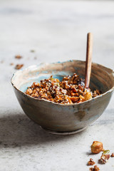 Crispy homemade granola with dried fruits and nuts in bowl.