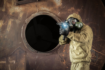 Soldier in the gas mask and with rifle in danger zone.