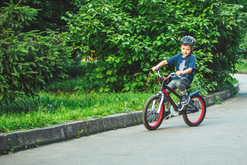little boy riding on bicycle in helmet