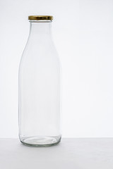 La bouteille en verre vide.