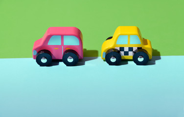 Two brightly colored wooden toy cars